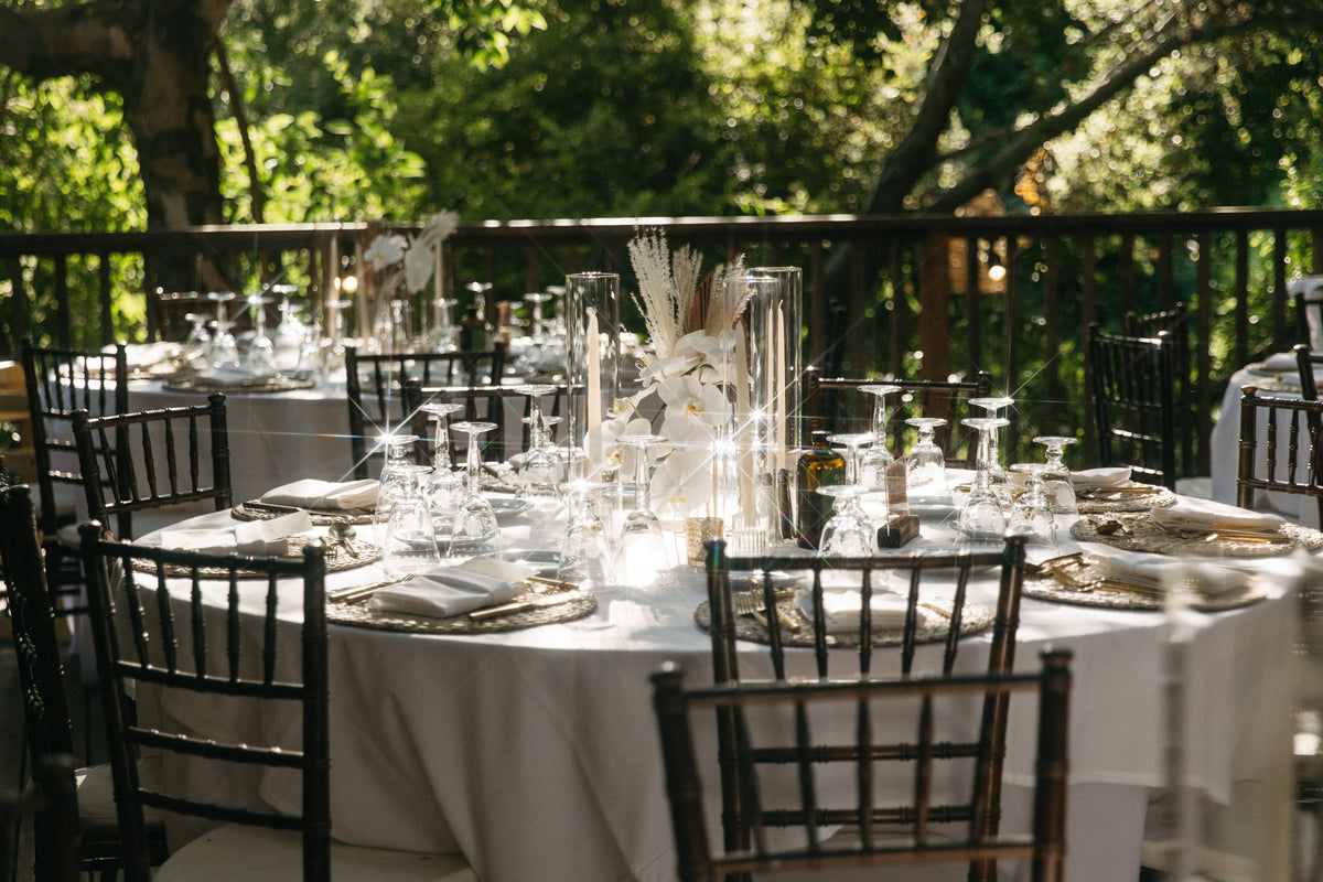 A boho wedding at the Birchwood space at Calamigos Ranch table setting with an orchid minimalist centerpiece, surrounded by ivory taper candles.