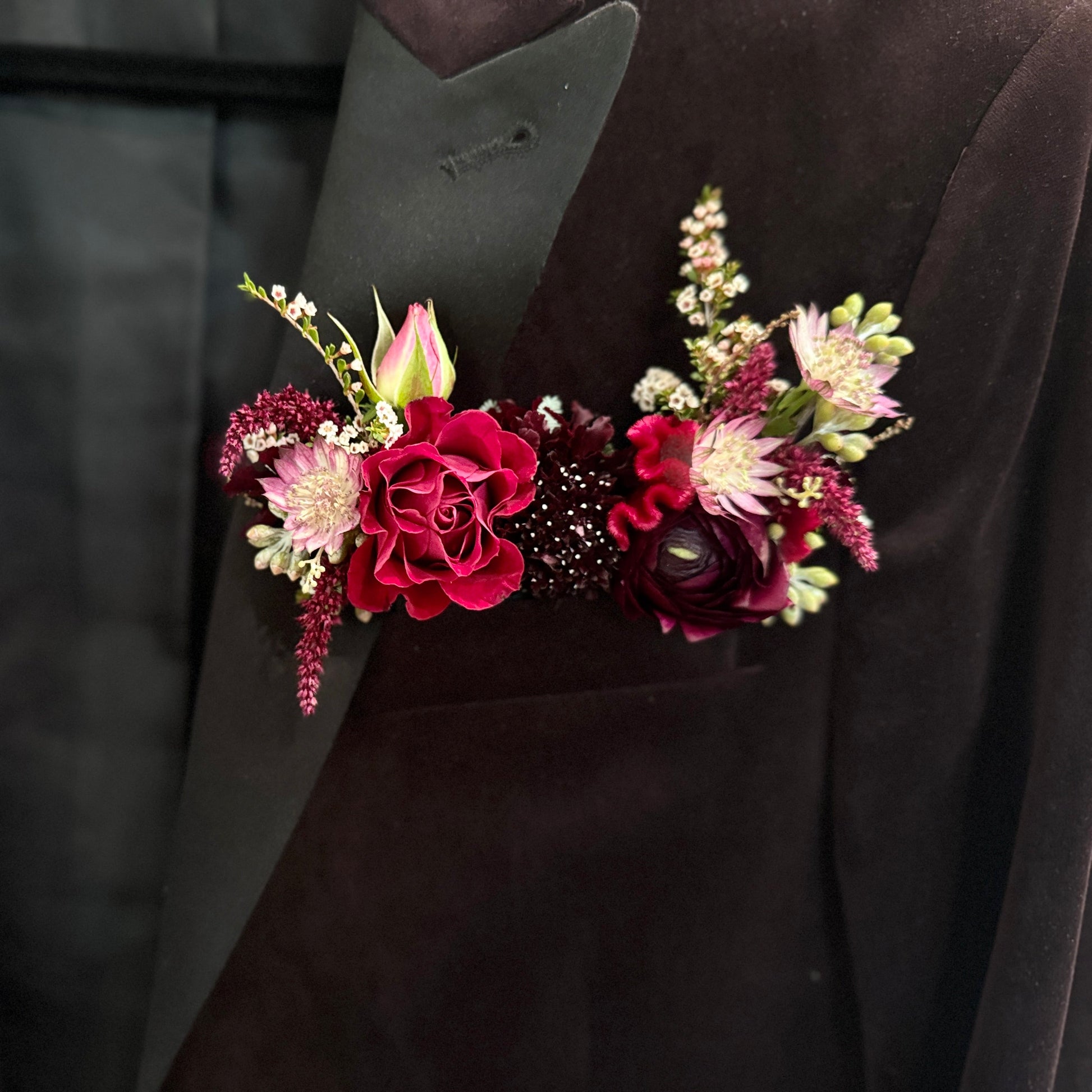 Floral arrangement in a pocket of a dark suit jacket