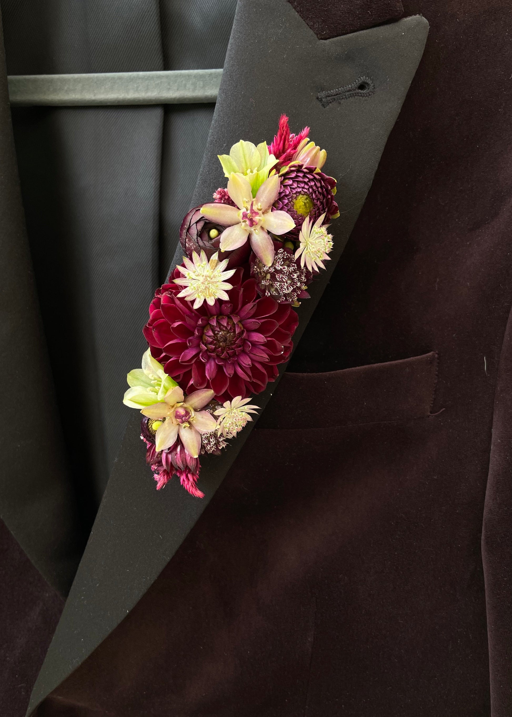 Burgundy and Blush lapel piece boutonniere on a dark suit jacket