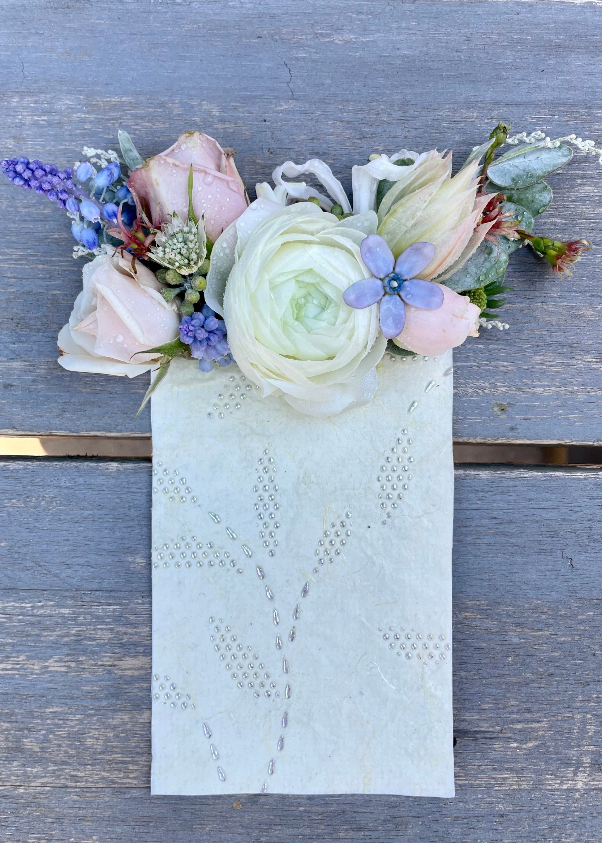 Blush and cream pocket square boutonniere with a pop of light blue