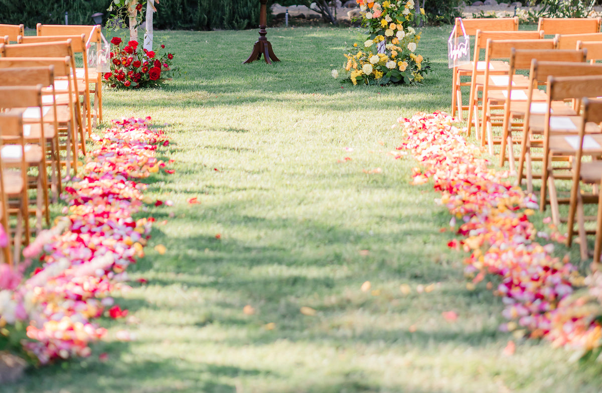 Pink peach and red rose petals along a wedding aisle