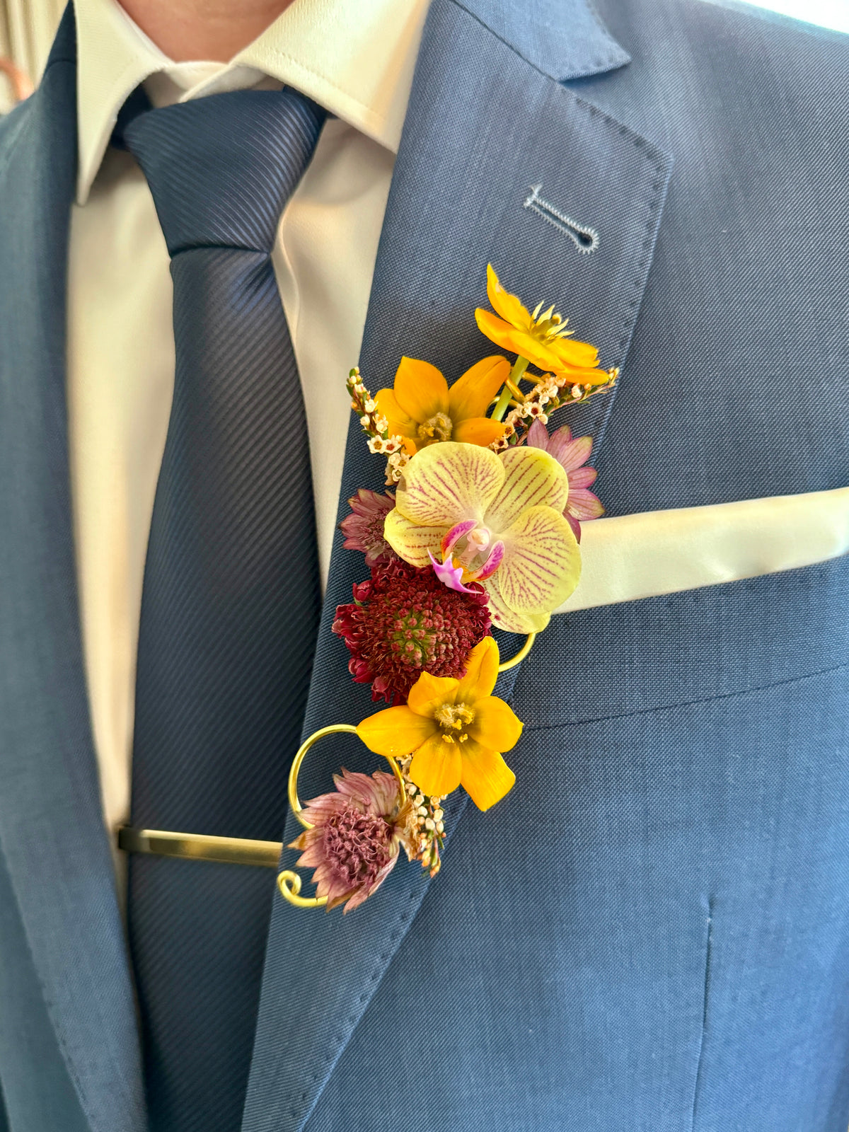 Artful and brightly colored jacket boutonniere